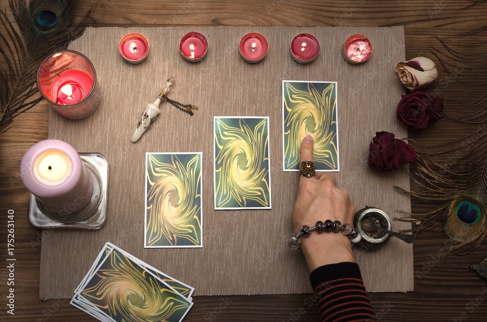 Fortune teller reading future with tarot cards. Paranormal desk table.  Fortune teller pointing by finger at Tarot card. Stock Photo | Adobe Stock