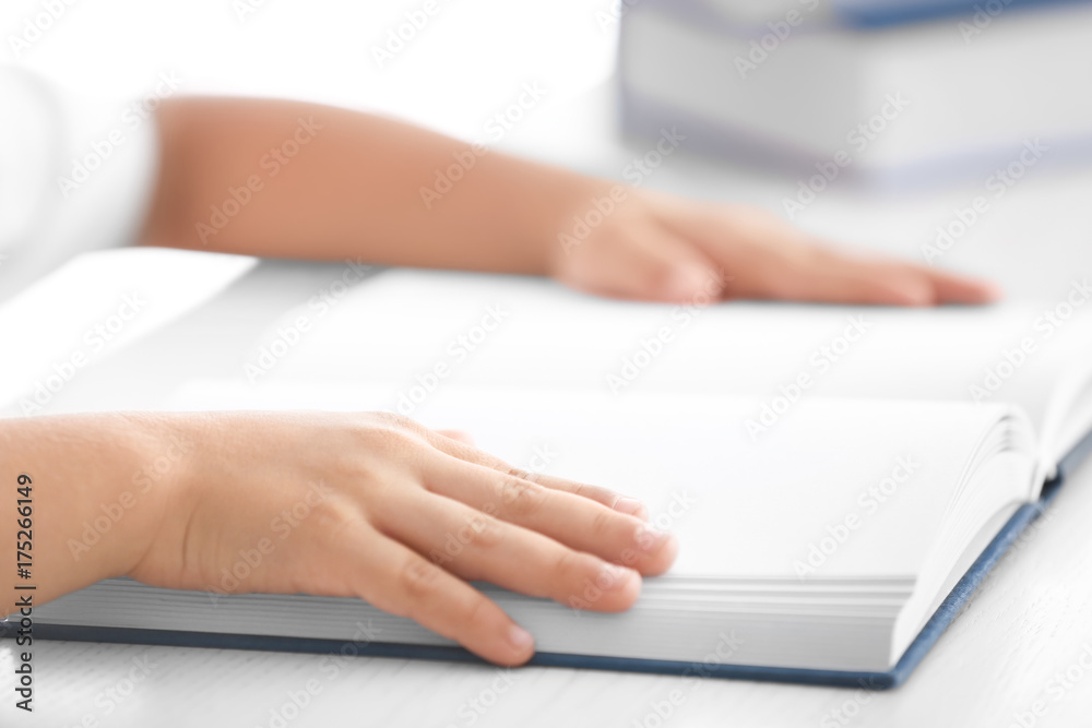 Hands of cute little boy reading book, closeup