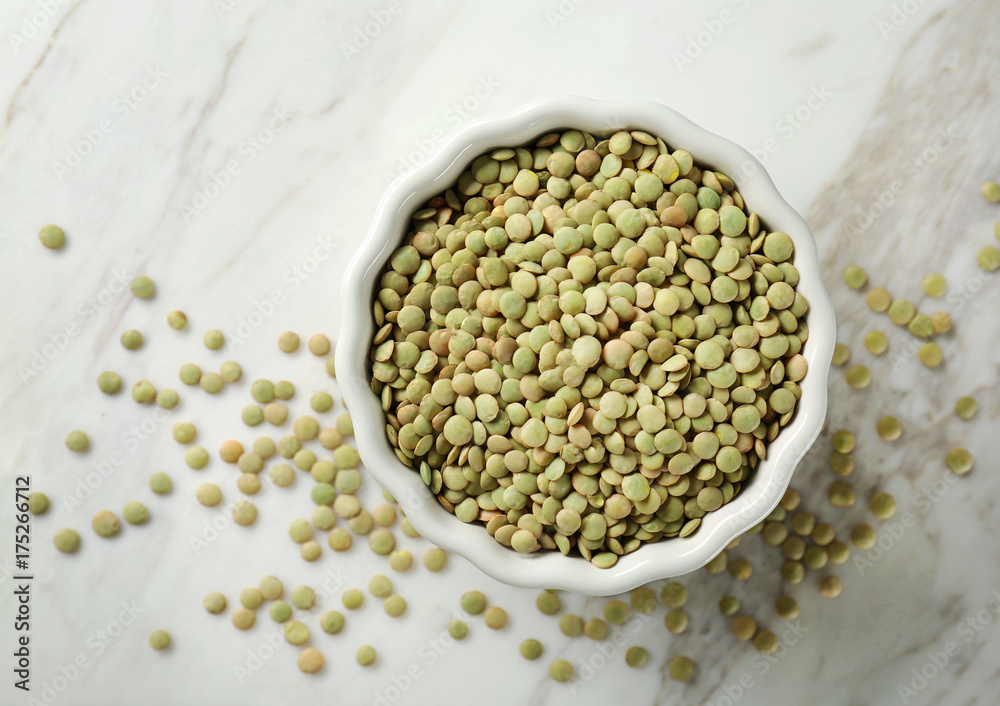 Bowl with green lentils on wooden table Bowl with green lentils on wooden table