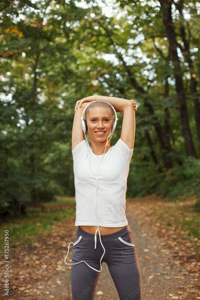 Young fitness woman runner stretching arms before run Young fitness woman runner stretching arms before run