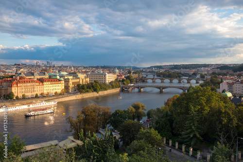 View of the city of Prague and bridges over the river Vltava in the evening.  The city is lit by the setting sun