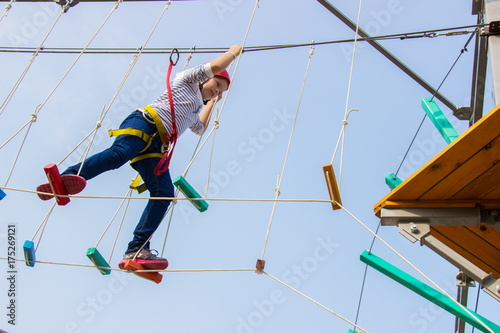 Little girl climbing on an outdoor ropes course.