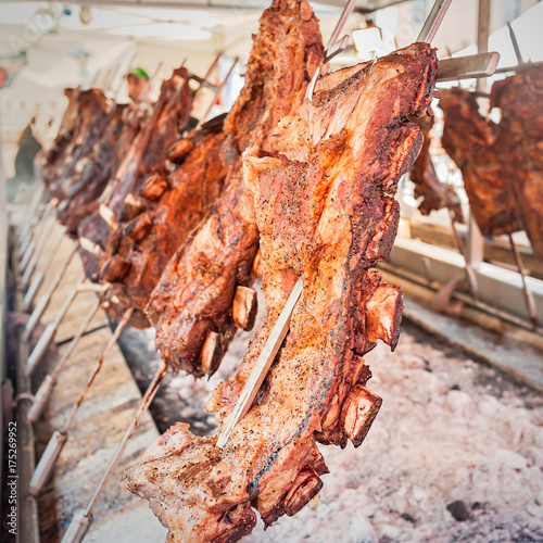 Roasted meat of beef cooking. Asado is traditional Argentine dish.