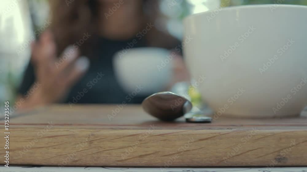 Woman in cafe holding a cup of coffee and talking close-up Woman in cafe holding a cup of coffee and talking close-up