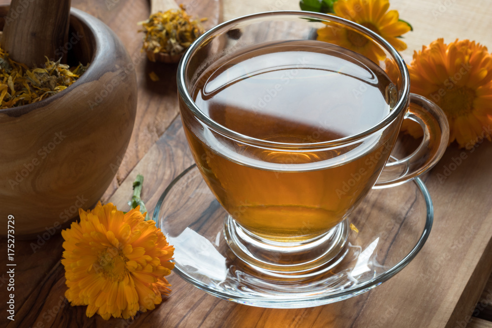 Calendula tea with calendula flowers on a wooden table Calendula tea with calendula flowers on a wooden table