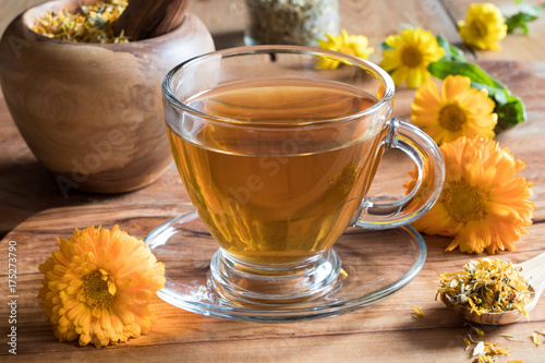 Fotografía Calendula tea with calendula flowers on a wooden table