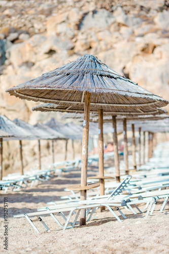 Beach wooden chairs and umbrellas for vacations on beach in Greece