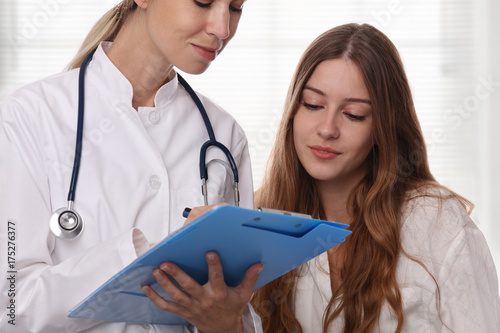 Smiling female doctor showing to teenage patient test results. Medical consultation