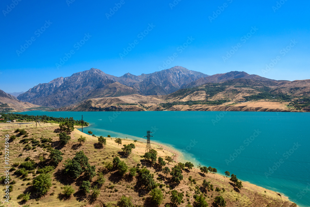 Panoramic view of Charvak Lake, artificial lake-reservoir created by  erecting a high stone dam on the Chirchiq River, and range of mountains on  the background located in Tashkent region of Uzbekistan Stock