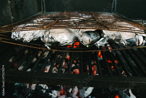 Fresh fish with lemon, garlic and herbs on barbeque grill - gilthead seabream