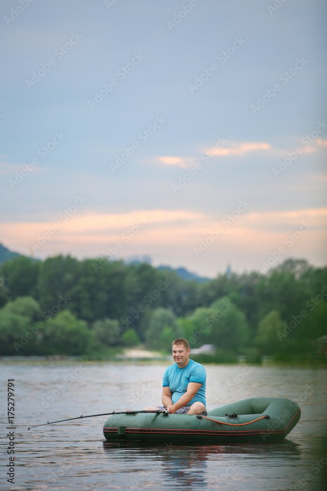 Man fishing from inflatable boat on river