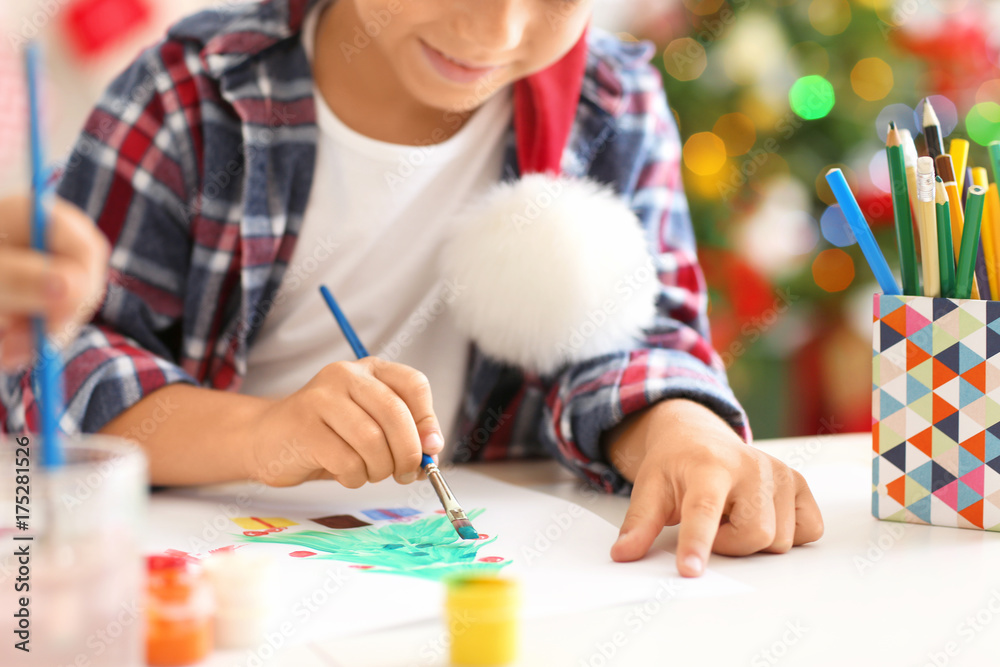 Fototapeta premium Cute boy painting Christmas fir tree at table