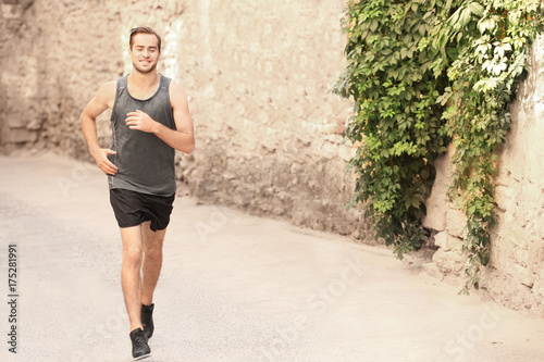 Fototapeta Naklejka Na Ścianę i Meble -  Sporty young man running outdoors