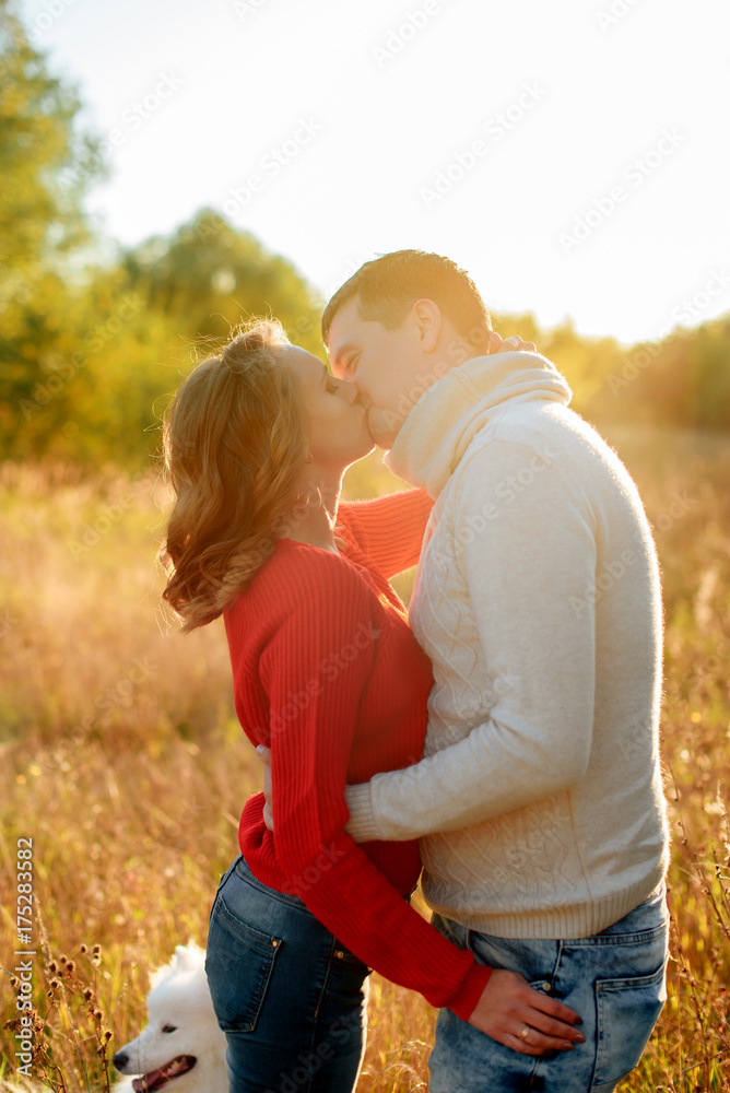 young loving couple hugging at sunset in autumn at an outdoor park