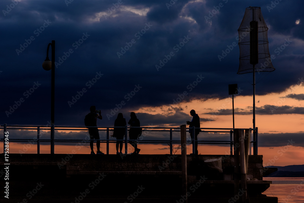 Silhouette of people on a dock