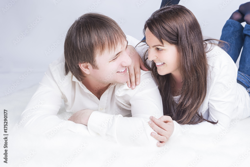 Family Ideas. Portrait of Happy Smiling Caucasian Couple Laying Together. Embracing and Looking into Each Other Eyes with .Holding Hands In Touch. Family Ideas. Portrait of Happy Smiling Caucasian Couple Laying Together. Embracing and Looking into Each Other Eyes with .Holding Hands In Touch.