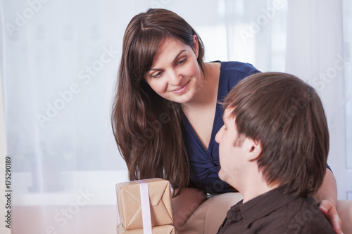 Wallpaper Mural Portrait of Caucasian Brunette Wife Giving a Present to Her Husband Indoors. Torontodigital.ca