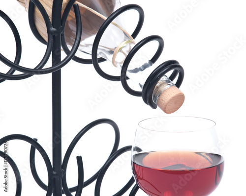 Red pomegranate wine, wine straw bottle and iron wine bottle holder isolated on white background