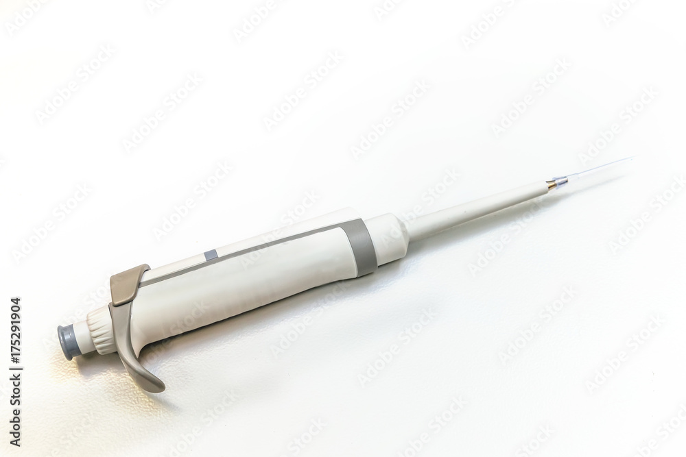 Automatic pipette dispenser on white laboratory table Automatic pipette dispenser on white laboratory table