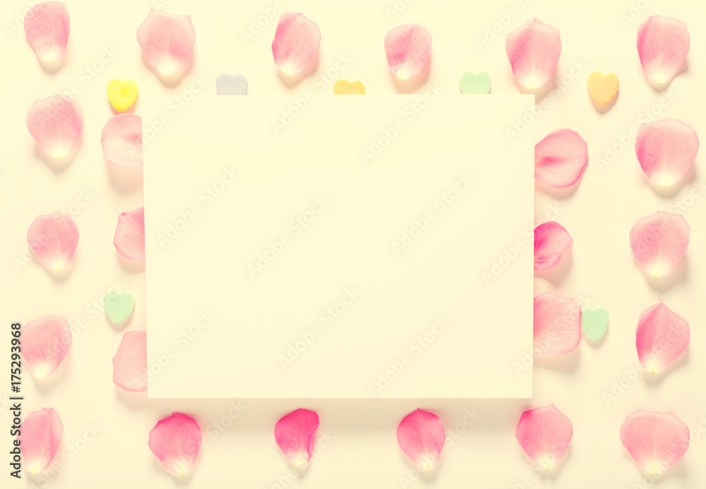 Rose petals and blank white message card aligned on a white background Rose petals and blank white message card aligned on a white background