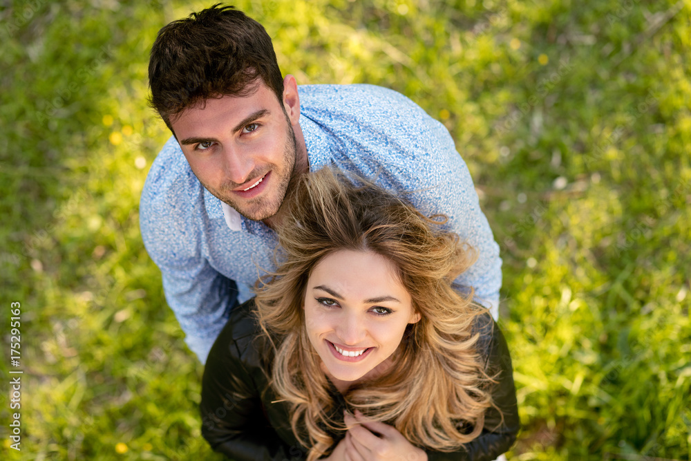 Top view. cheerful couple, standing barefoot in the grass looking at camera. Top view. cheerful couple, standing barefoot in the grass looking at camera.