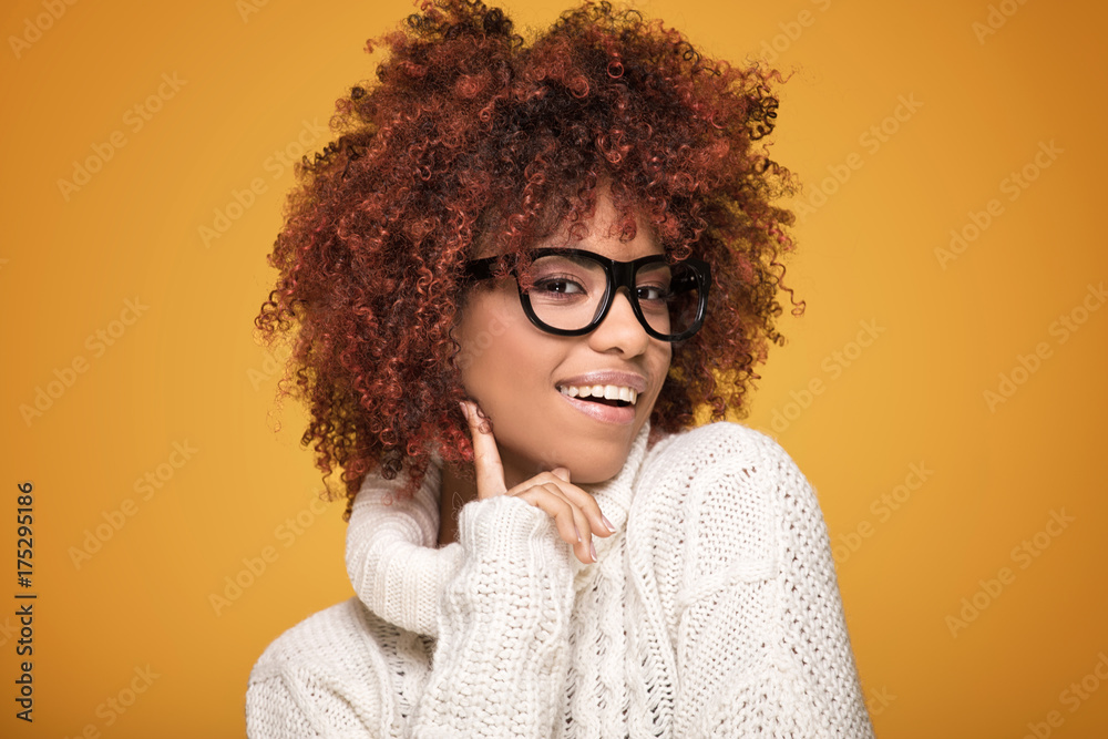 Young african american girl on yellow background.