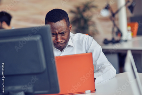 Disappointed African businessman is dazed and confused by a mistake in official documents.