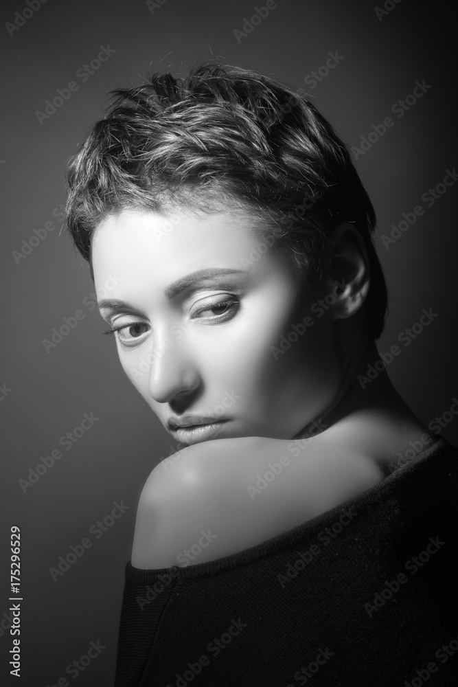 portrait of beautiful sensual woman with closed eyes in black clothes with naked shoulder on dark background 
