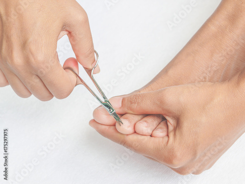 Closeup young woman cutting her feet nails. Health care and beauty concept.