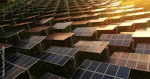 4K Aerial view of Solar Panels Farm (solar cell) with sunlight.Drone flight fly over solar panels field renewable green alternative energy concept in Thailand.