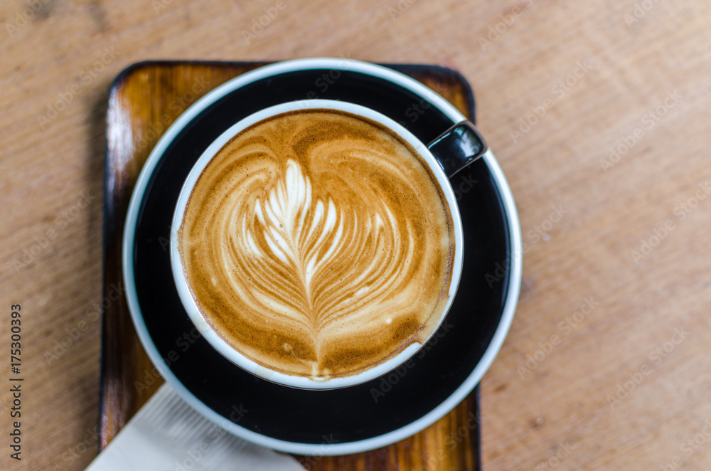 coffee latte art on wood table in cafe, selective focus top view coffee latte art on wood table in cafe, selective focus top view