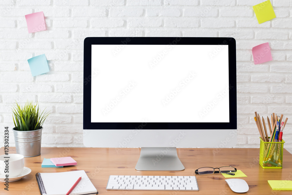 workspace with computer with blank white screen, and office supplies on a wooden desk workspace with computer with blank white screen, and office supplies on a wooden desk