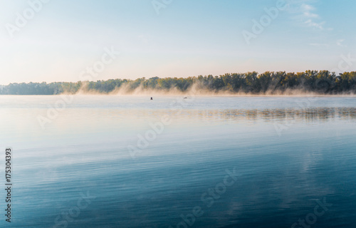 Morning clubs of autumn fog over the river