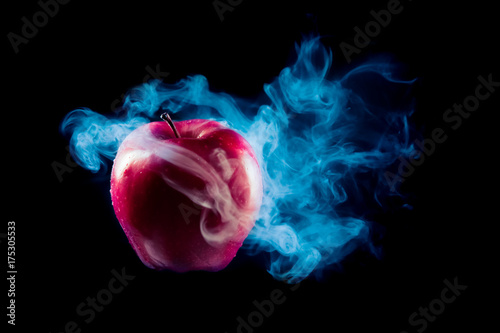 poisoned apple with dramatic lighhting on a black background