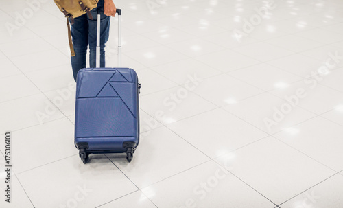 Asian woman passenger holding suitcase in airport terminal,travel concept.