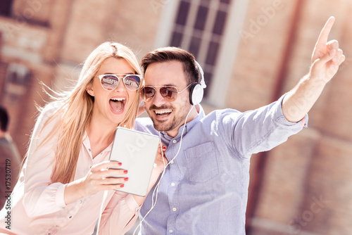 Couple listening to music on tablet in the city