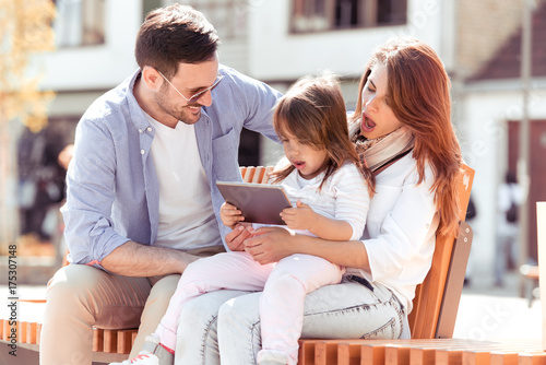 Young family using tablet in city. © ivanko80