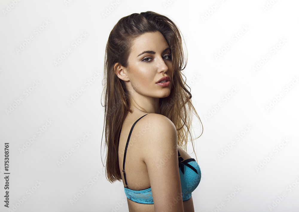 Obraz premium Close-up, beauty portrait of a young brunette woman dressed in a light blue bra