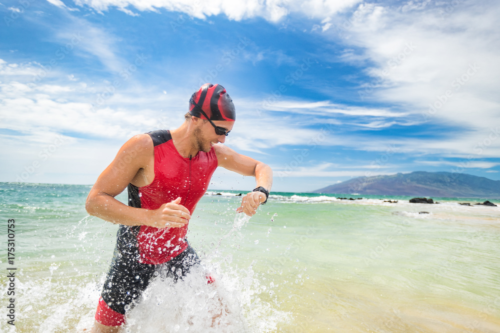 Smartwatch triathlon swimming sport man finishing swim checking heart rate  on smart watch. Male triathlete swimmer running out of ocean. Professional  athlete in triathlon suit training for ironman. Stock Photo | Adobe