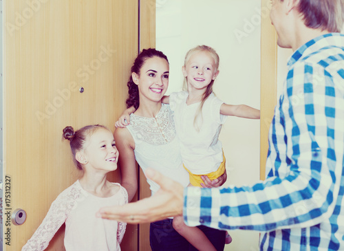 Adults and kids meeting at doorway and greeting one another