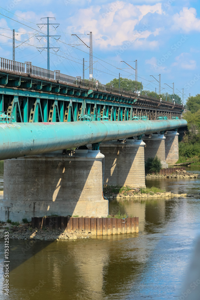 Green 6 span steel truss Gdanski Bridge across the River Vistula, with historic pillars of the Citadel bridge, with 2 elevations, upper part serves road transport, the lower part serves tram traffic Green 6 span steel truss Gdanski Bridge across the River Vistula, with historic pillars of the Citadel bridge, with 2 elevations, upper part serves road transport, the lower part serves tram traffic