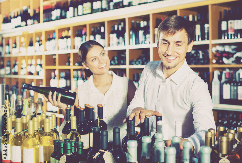 Portrait of  male and female customers picking bottle of wine