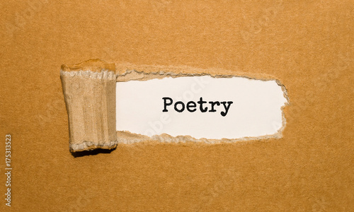 The text Poetry appearing behind torn brown paper