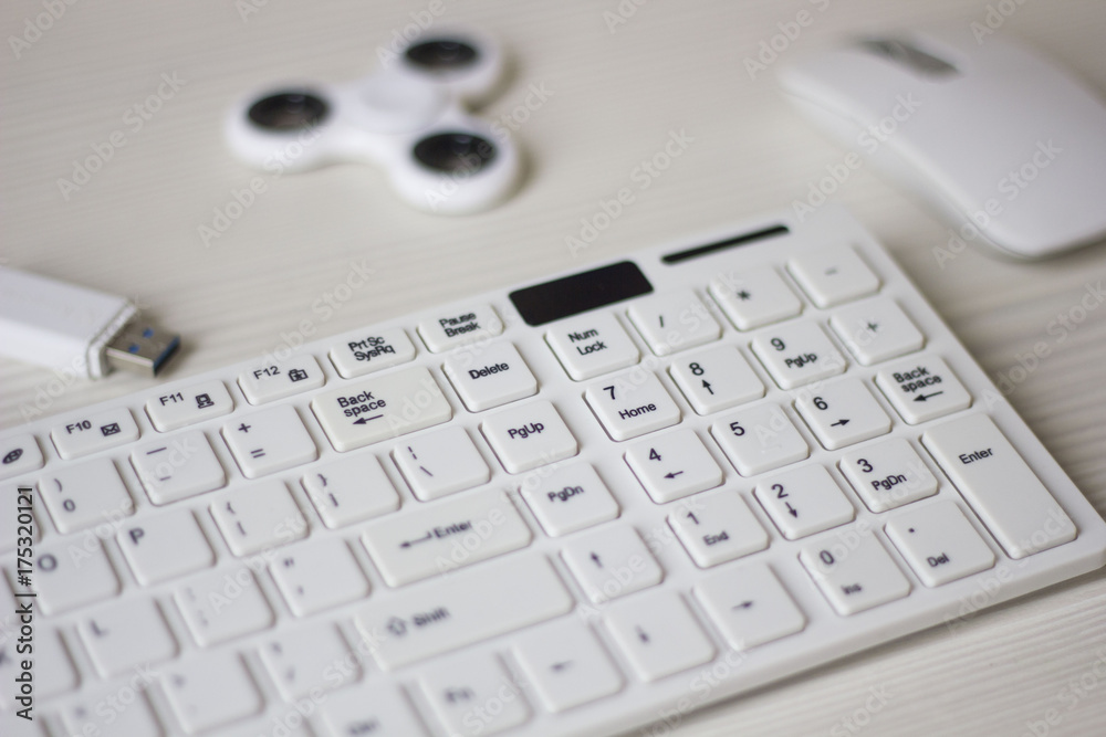 white computer mouse, spinner, flash card and keyboard on a white table, business concept white computer mouse, spinner, flash card and keyboard on a white table, business concept