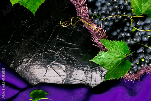 Red wine grapes in voiolet basket on bllack background. Top view. Copy space. photo