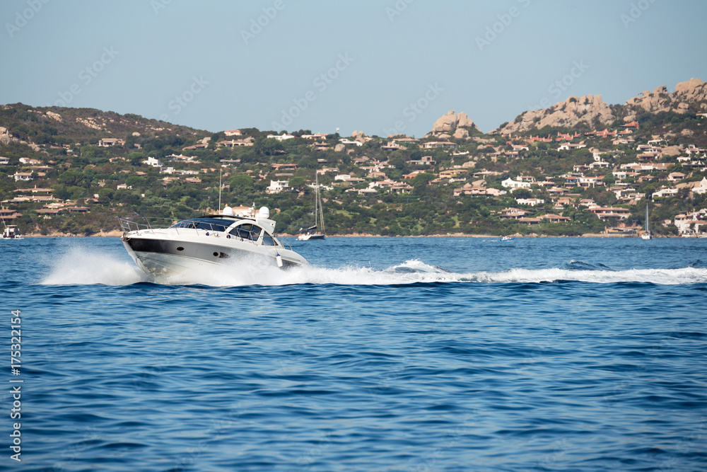 Obraz premium Small motor boat on sea, Sardinia island in background