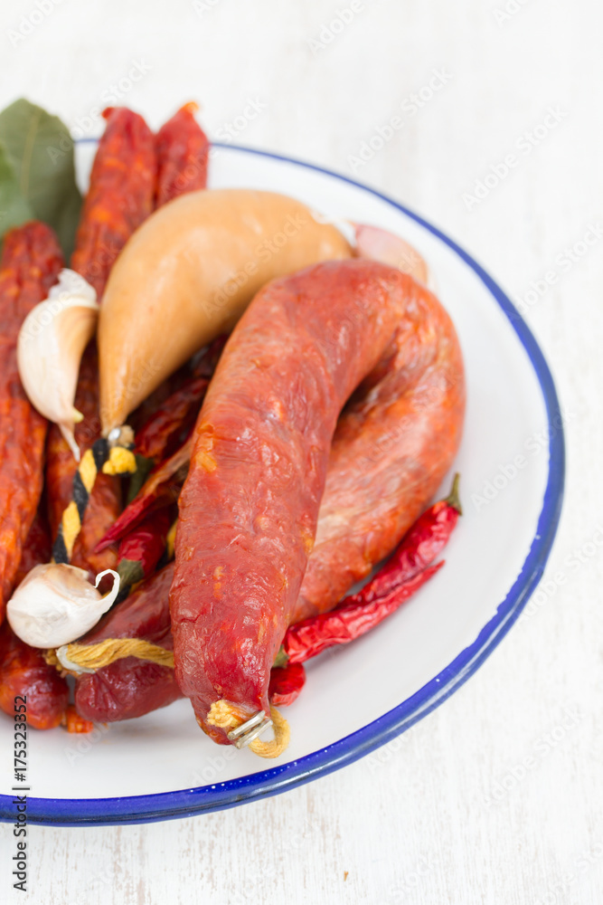 smoked sausages on white dish on wooden background smoked sausages on white dish on wooden background