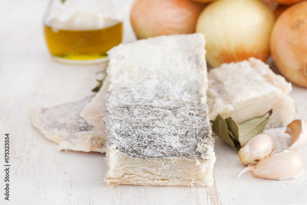 dry cod fish with onion on wooden background dry cod fish with onion on wooden background