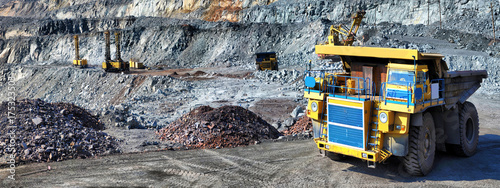 Heavy dump truck carrying the iron ore on the opencast mining photo