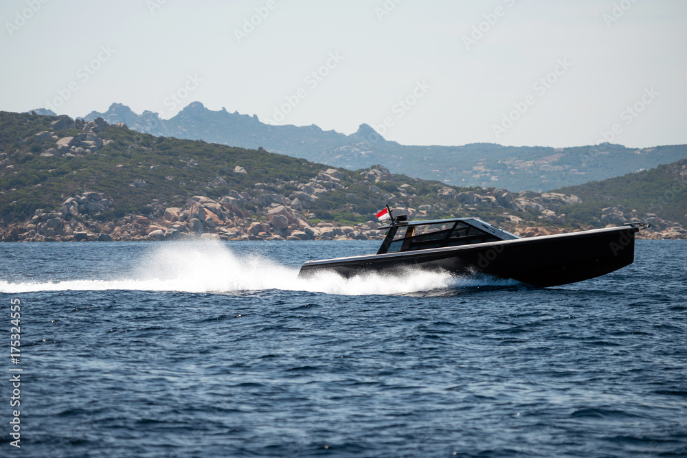 Fototapeta premium Small motor boat on sea, Sardinia island in background
